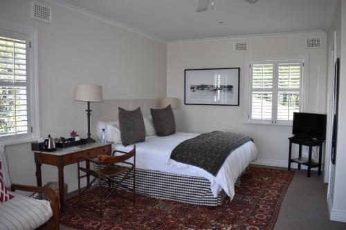 1 dormitorio con 1 cama y escritorio con ordenador en Southey House en Kloof