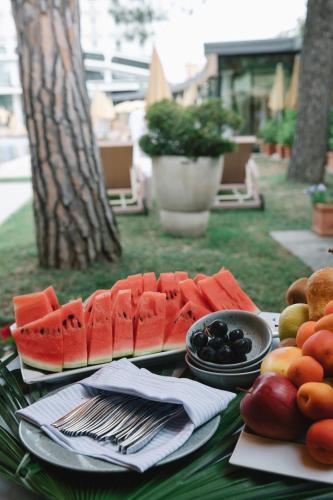 a table topped with plates of fruit on a table at Hotel President Terme in Abano Terme