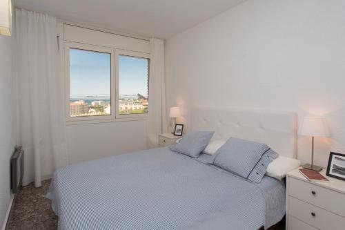 una camera bianca con un letto e una finestra di Tranquilidad junto al mar con piscina a Sant Andreu de Llavaneres