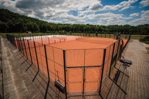 a tennis court with an orange tennis net at K-Triumf Resort in Velichovky