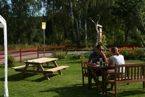 a man and woman sitting at a picnic table at Bed & Breakfast Björkhyddan in Rumma