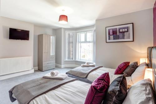 a bedroom with two beds and a tv at Clen Holme House in Crewe