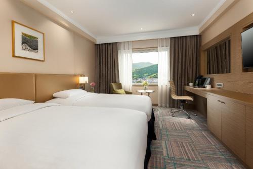 ソウルにあるノボテル アンバサダー ソウル江南のベッド2台とテレビが備わるホテルルームです。