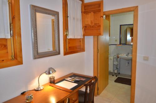 a room with a desk and a bathroom with a sink at Residencia Ziri in Granada