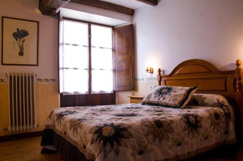 um quarto com uma cama e uma grande janela em Casa Rural ERTEIKOA - Selva de Irati em Aria