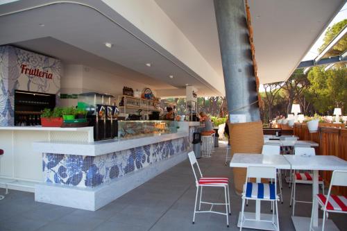 a restaurant with a counter and tables and chairs at Camping Village Roma Capitol in Ostia Antica