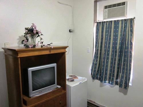 a living room with a tv and a washing machine at Hotel Ste-Catherine in Montreal