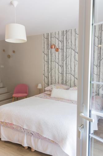 a bedroom with a bed with trees on the wall at Le Mas des Alexandrins in Uzès
