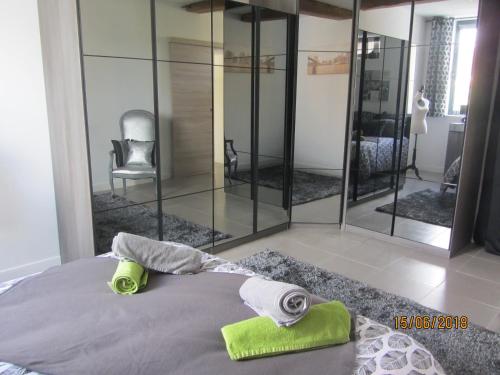 a bed with two towels and a chair in a room at TESS Villa Fournadin in Fournaudin