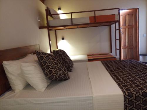 a bed with two bunk beds in a room at Inn On The Bay in Pasikuda