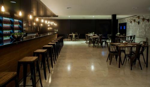 Un restaurante con mesas y sillas y un bar. en La Casita de la Planta, en Quintanilla de Onésimo