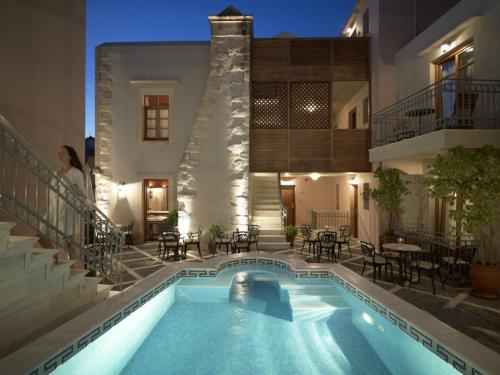 a swimming pool in front of a house at night at Palazzo Vecchio Exclusive Residence in Rethymno