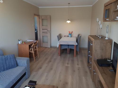 a living room with a table and a blue couch at Apartament Kinio in Gdańsk