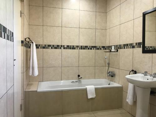 ein Badezimmer mit einer Badewanne und einem Waschbecken in der Unterkunft 44 on Brownlee in Kokstad