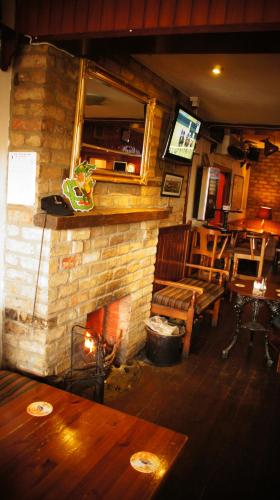 a living room with a fireplace and a table and chairs at Dalys Inn in Donore