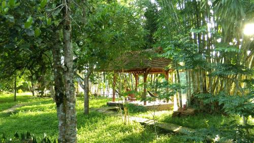 a pavilion in the middle of a park with trees at Green Hope Lodge in Cat Tien