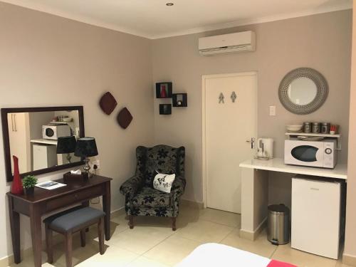 a room with a desk and a chair and a mirror at 44 on Brownlee in Kokstad