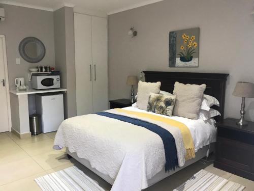 ein Schlafzimmer mit einem großen Bett und einer Mikrowelle in der Unterkunft 44 on Brownlee in Kokstad