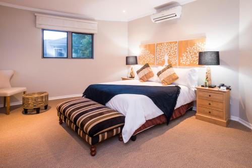 a bedroom with a large bed and a chair at aha Kopanong Hotel & Conference Centre in Bredell