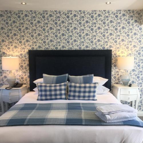 a bedroom with a bed with blue and white pillows at The George Great Oxendon in East Farndon