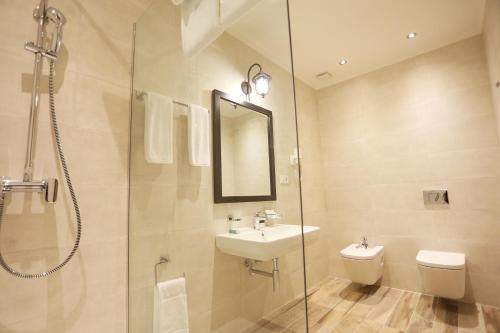 a bathroom with a sink and a shower and a toilet at Ambassadori Kachreti Golf Resort in Kachretʼi