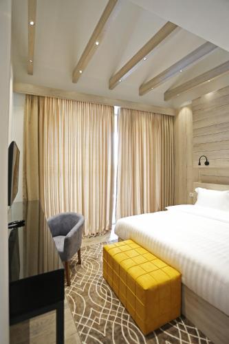 a hotel room with a bed and a chair at Ambassadori Kachreti Golf Resort in Kachretʼi