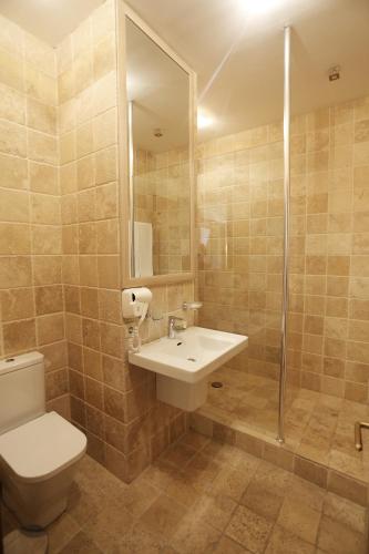 a bathroom with a toilet and a sink and a shower at Ambassadori Kachreti Golf Resort in Kachretʼi