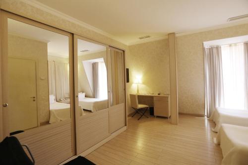 a hotel room with a bathroom and a bedroom at Ambassadori Kachreti Golf Resort in Kachretʼi