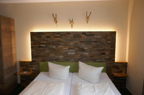 a bedroom with a bed with a brick wall at Landhaus Krone in Steinach