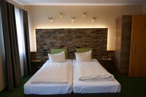 two beds in a hotel room with lights on the wall at Landhaus Krone in Steinach