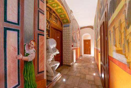 a woman standing in a hallway with paintings on the walls at Hostel Archi Rossi in Florence