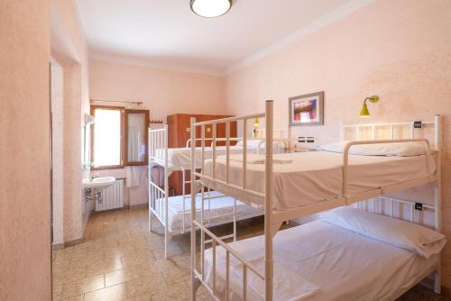a room with two bunk beds and a bathroom at Hostel Archi Rossi in Florence