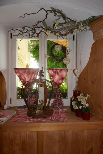 a room with a window and a table with a basket of flowers at Landhaus Krone in Steinach