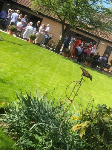 a bird standing on top of a grass field at The George Great Oxendon in East Farndon