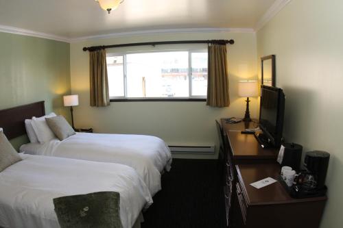a hotel room with two beds and a television at The Mammoth Creek Inn in Mammoth Lakes