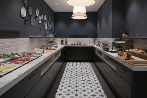 a large kitchen with a buffet line with food at Hotel Am Leuchtturm in Warnemünde