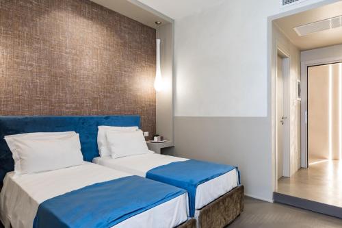 two beds in a hotel room with blue and white at A World Aparts - Barberini Boutique Hotel in Rome