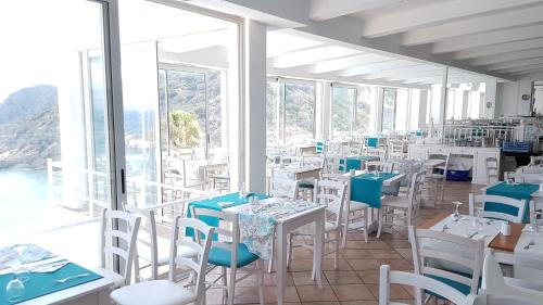 a restaurant with white tables and chairs and windows at Istron Bay Hotel in Istro