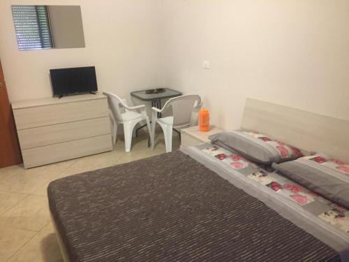 1 dormitorio con cama, mesa y TV en Le Villette, en Pescara