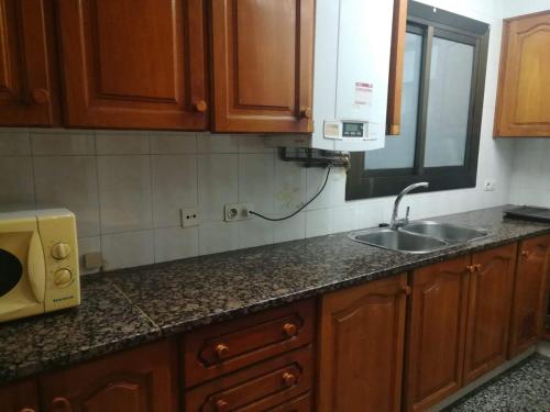 a kitchen counter with a sink and a microwave at Encantador apartamento cerca de la playa in Malgrat de Mar