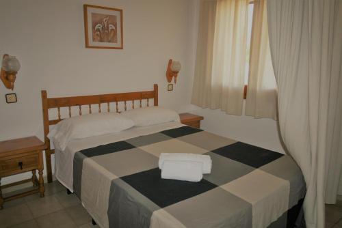 エンプリアブラバにあるVista Bahia 11 Empuriabravaのベッドルーム1室(チェック入りの毛布付きのベッド1台付)