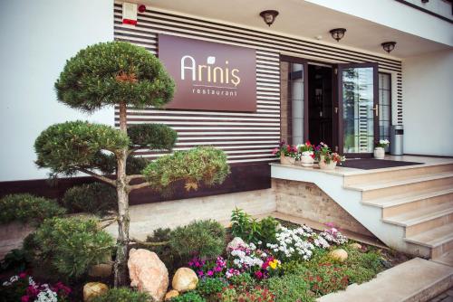 a building with a flower garden in front of a store at Piatra Pinului Ski & Spa in Gura Humorului