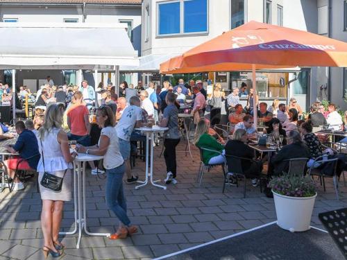 a group of people sitting at tables in a patio at Hasse på Sjökanten Hotell & Restaurang in Jönköping