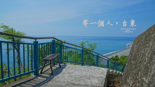 a bench sitting on a balcony overlooking the ocean at 台東愛格斯 單車友善&溯溪&包車旅行 EGGS Bike & River tracing & Chartered car tour in Taitung City