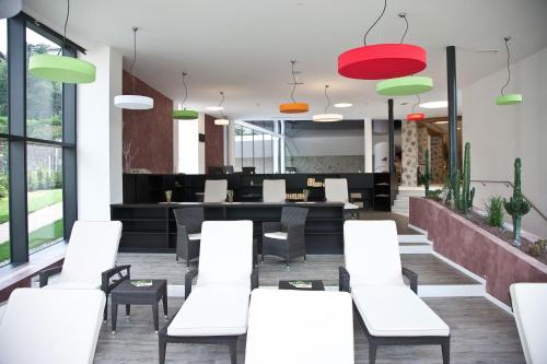 a restaurant with white tables and chairs and windows at Hotel Grüner Baum in Bressanone