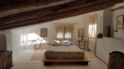 a bedroom with a bed in a room with beams at Casa Rural El Almendro in Rozalén del Monte