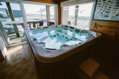 Cette chambre dispose d'une baignoire et offre une vue sur la plage. dans l'établissement Villa Lodge Natureo, à Seignosse