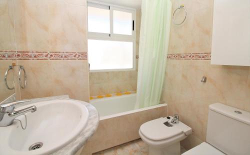 a bathroom with a sink and a toilet and a window at Albatros 13-1 in Benidorm