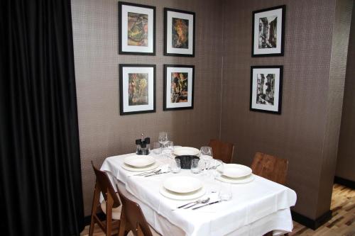 a table with white plates and napkins on it at Privilege Hotel & Spa in Tirana
