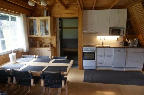 a kitchen with a table and chairs in a room at Ylläs Suistotie Cottage in Äkäslompolo
